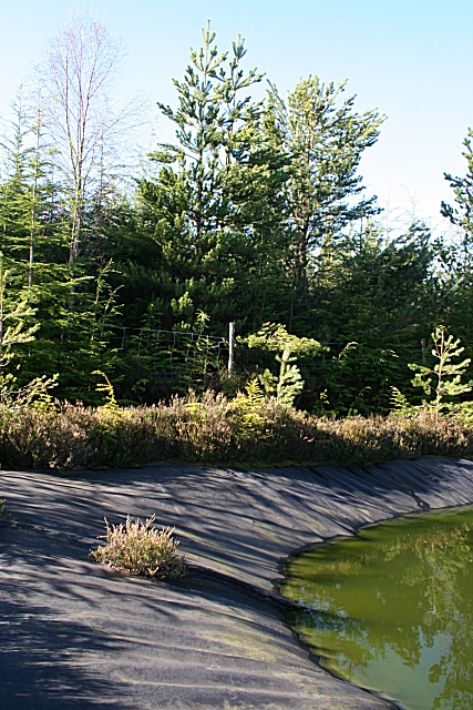 Pond with visible lining along part of its edge.