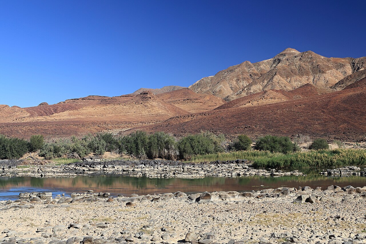 Orange River with a vegetated bank and arid mountains behind